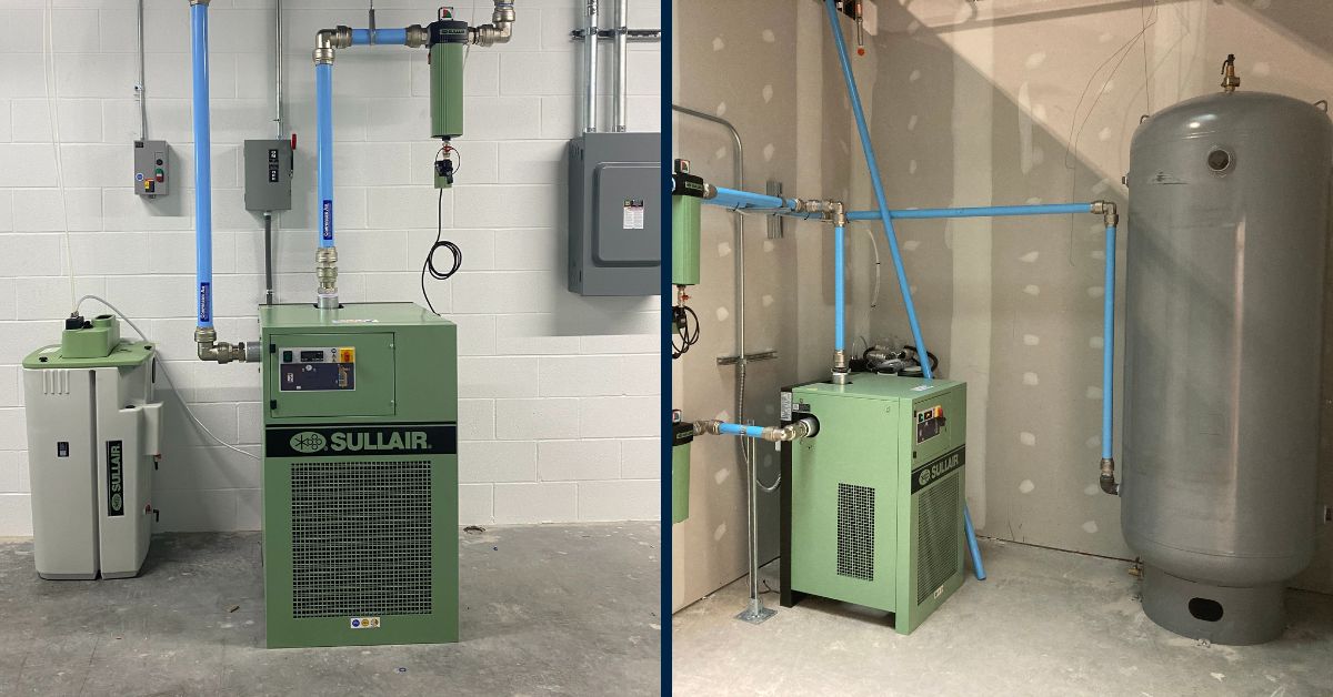CompressAir | Two industrial air compressors with Sullair branding, connected to pipes and electrical boxes in a mechanical room with concrete floor and white walls. One setup includes a large vertical gray tank.